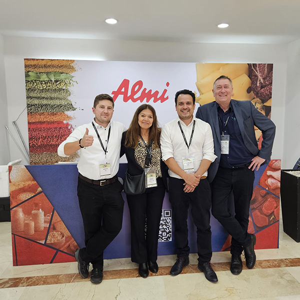 Aktuelle News von Almi. Ein Gruppenbild von Almi Mitarbeiter vor dem Messestand auf der Fachmesse in Bogota. 