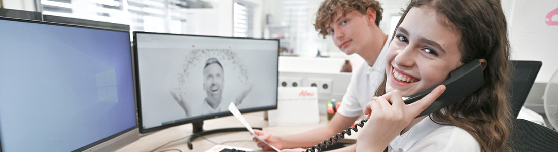 Ein Junge und ein telefonierendes Mädchen im Büro, dargestellt für die Bürokaufmann/frau Lehre in der Lebensmittelindustrie. 